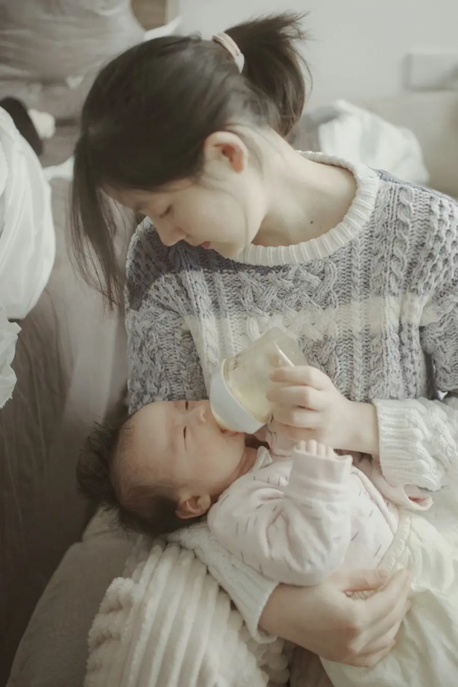 Người mẹ cho em bé bú bình